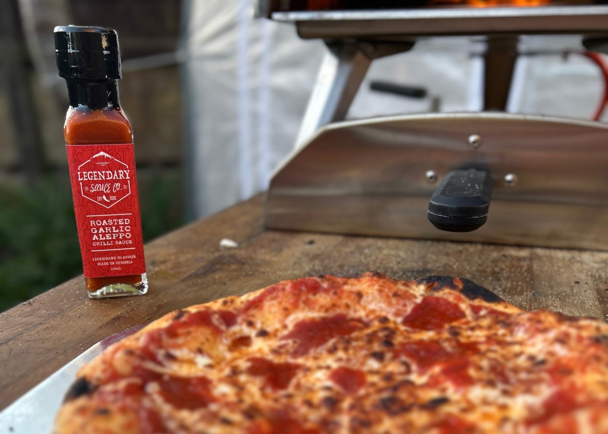 an image showing a bottle of hot sauce and a pizza