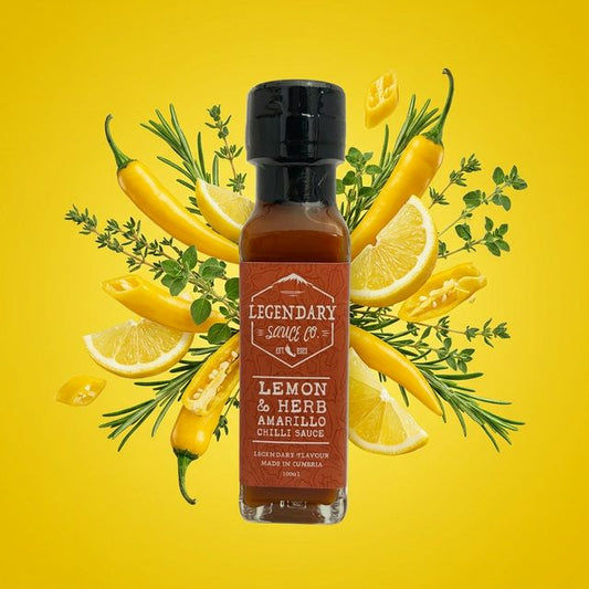 Bottle of Legendary Sauces Co. Lemon & Herb Amarillo Chilli Sauce surrounded by yellow peppers, lemons, and herbs on a yellow background.