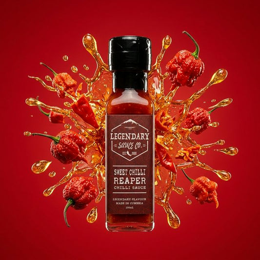 Bottle of Legendary Sauce Co. Sweet Chilli Reaper Chilli Sauce with chili peppers and sauce splashes on a red background